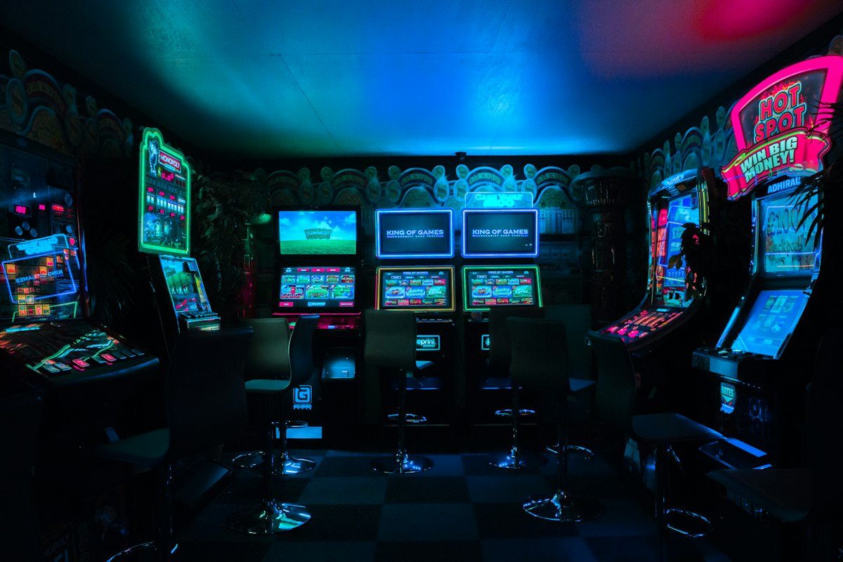 Retro arcade machines glowing in a dark room